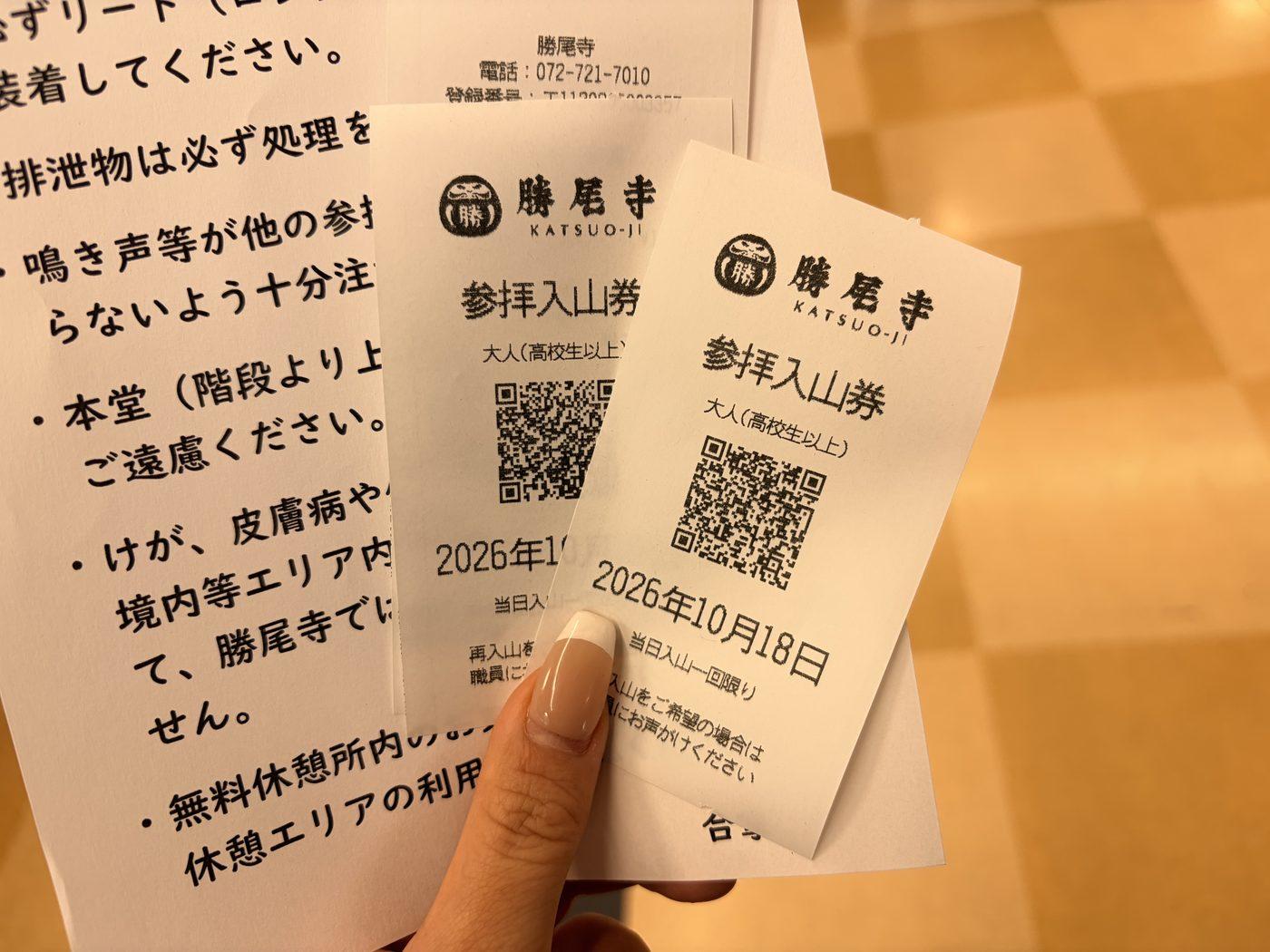 2026年10月18日の日付が入った、勝尾寺の参拝入山券2枚。後ろに犬のルールを書いた紙が重なっている